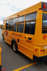 School bus rear-side view showing yellow Ford Blue Bird E-Series bus with Central School District lettering along the windows and stop sign area.