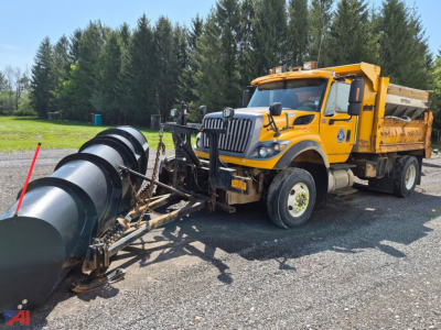 Truck with plow, wing, and sander attached; yellow International WorkStar 7600 dump truck shown from front-left side with large plow apparatus and snow removal equipment.