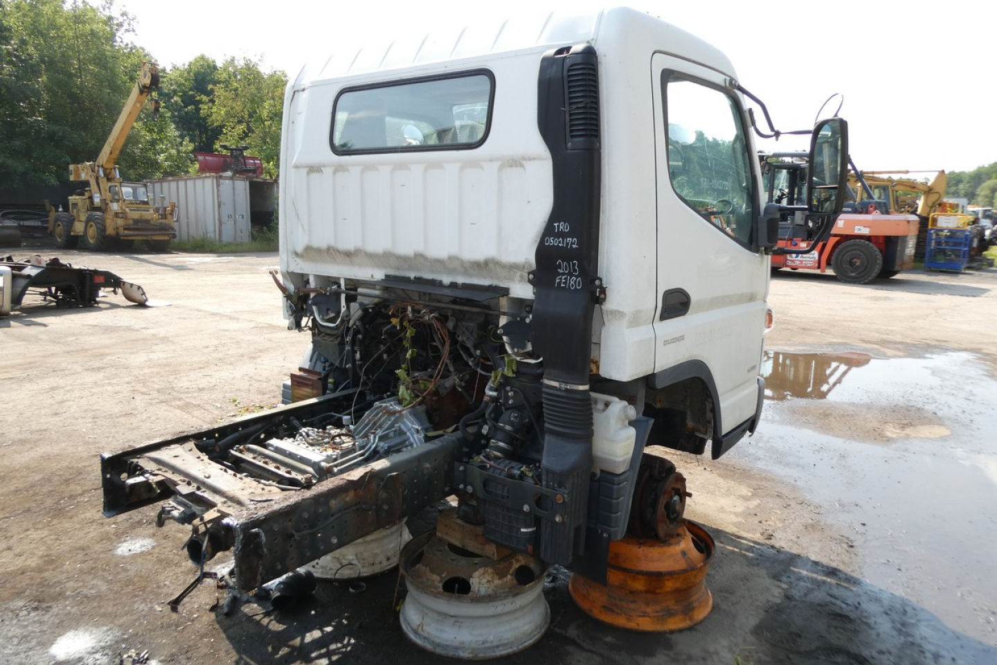 Mitsubishi Fuso FE180 cab and chassis truck with exposed chassis and removed cab, front wheels removed, various components visible.