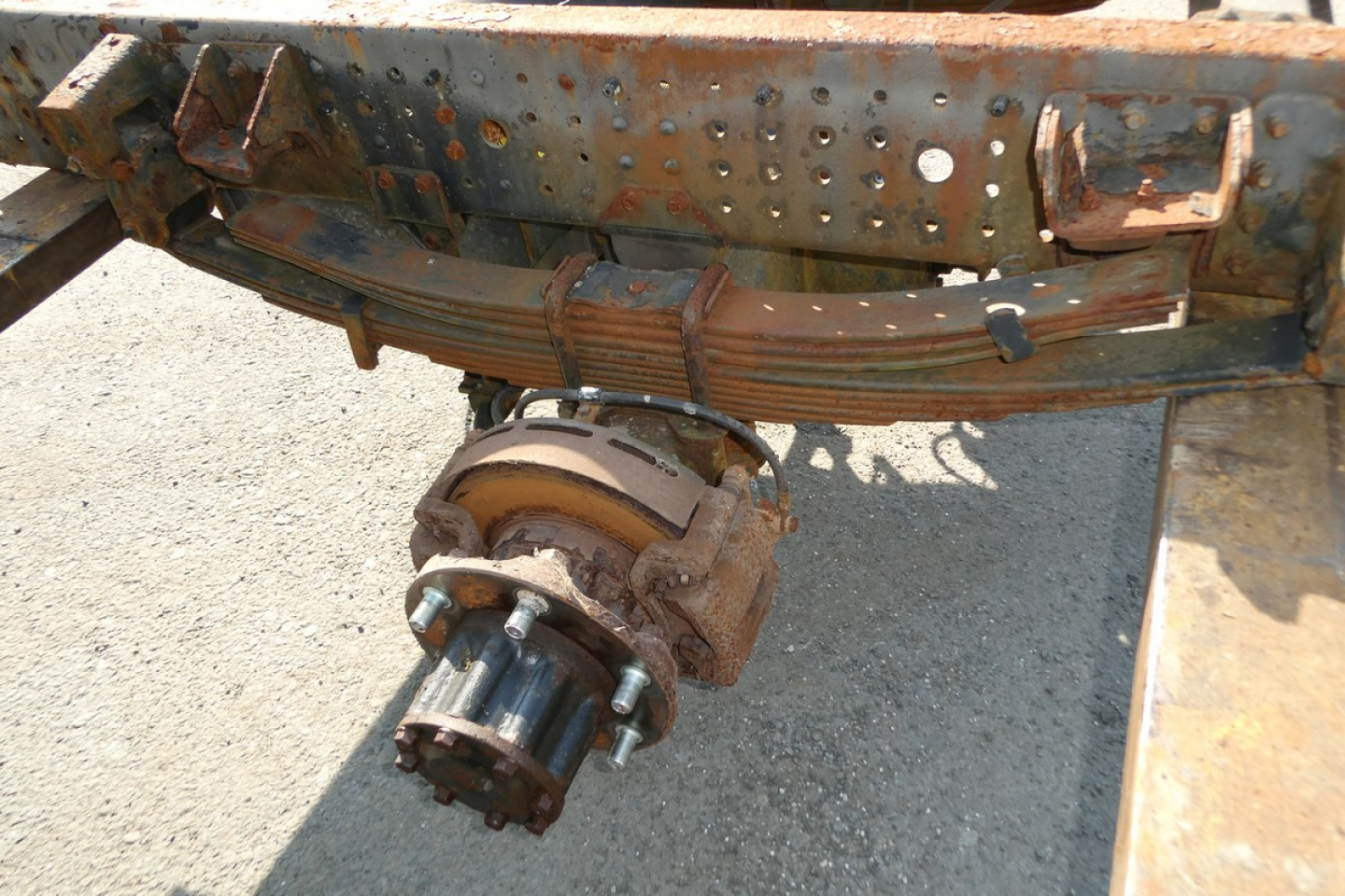 Mitsubishi Fuso FE180 cab and chassis rear with differential and axle assembly, rusty frame, exposed suspension components.