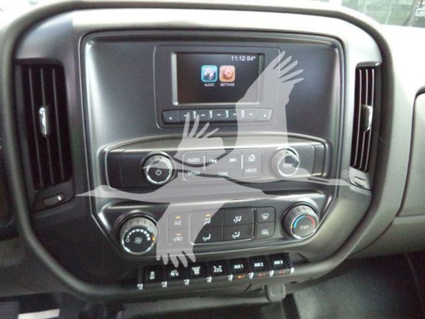 Dashboard of a truck with touchscreen display and climate controls visible; includes buttons and knobs on center console.