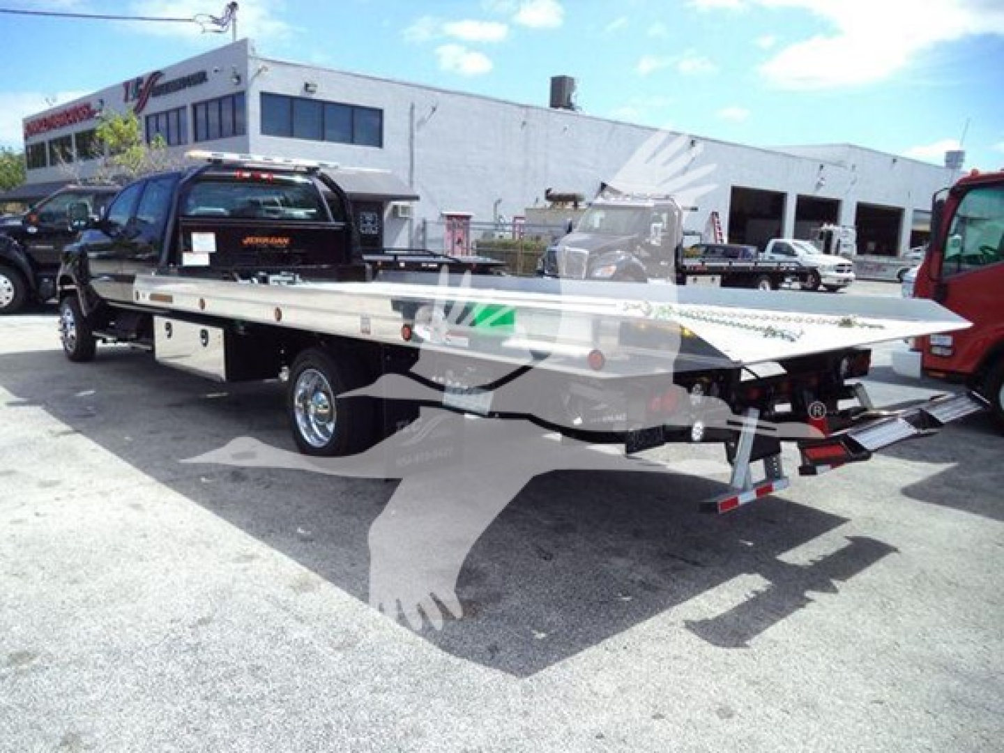 2023 International CV rollback truck with flatbed tow on trailer, VIN 1HTKTSWK9PH419807 visible in background lot; new/unused condition information.