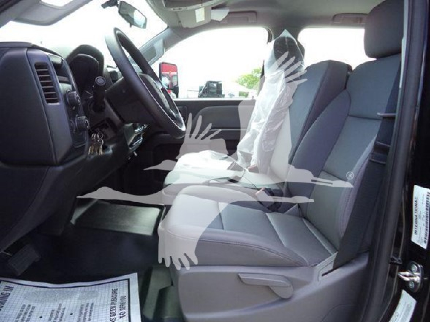 Interior of 2023 International CV rollback truck showing driver and passenger seats, steering wheel, dashboard, and protective plastic on seat.