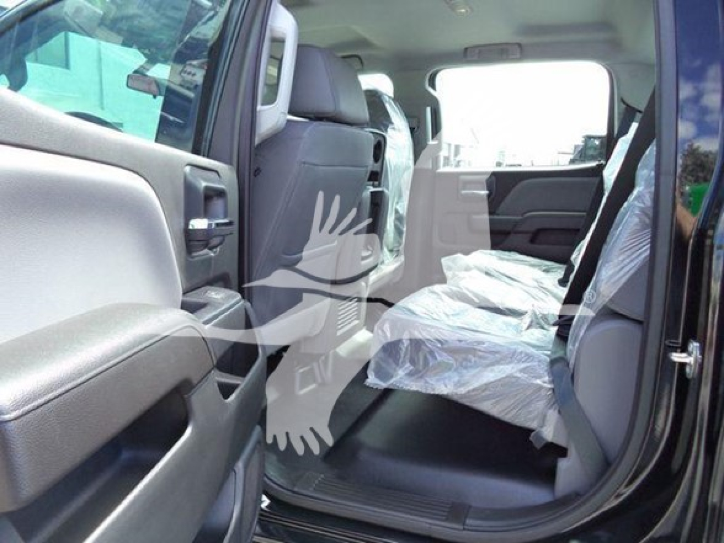 Truck interior showing back seat area and open rear passenger door, plastic seat covers, grey upholstery, and door panels.