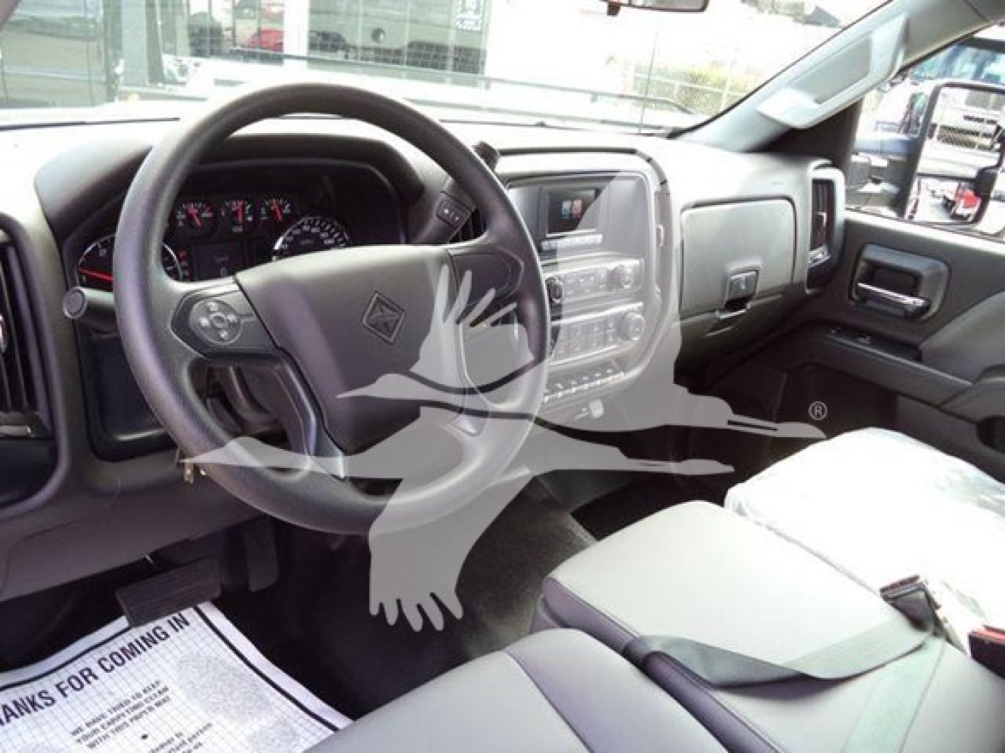 Truck interior showing steering wheel, dashboard, and front seats of a new International CV truck.