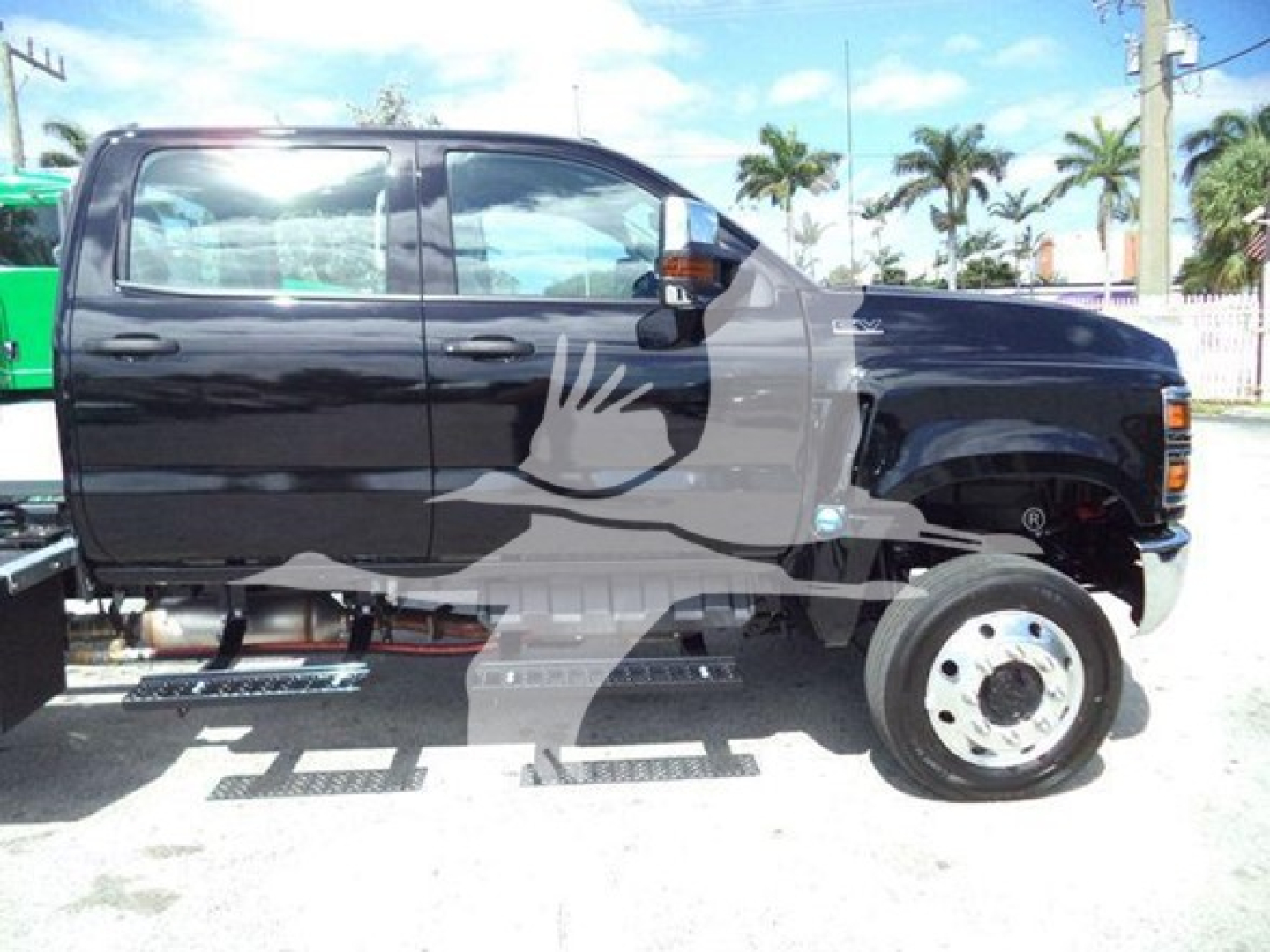 Black International CV Series rollback truck in side view with white decals; visible text includes none legible; side steps and rear duals; a watermark graphic across the middle.
