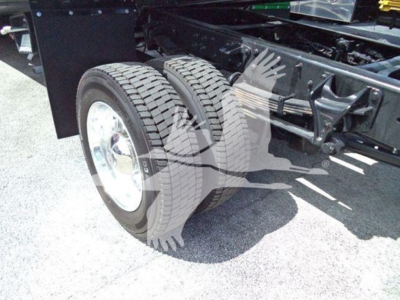 Truck rear dual wheels and chassis showing solid tires and suspension components.