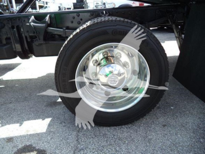 Truck rear wheel assembly and suspension viewed from side showing a polished steel rim and black tire with surrounding chassis components.