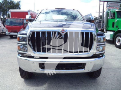 Front view of a new 2023 International CV rollback truck showing chrome grille, bumper, and headlights.