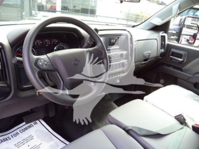 Truck interior showing steering wheel, dashboard, and front seats of a new International CV truck.