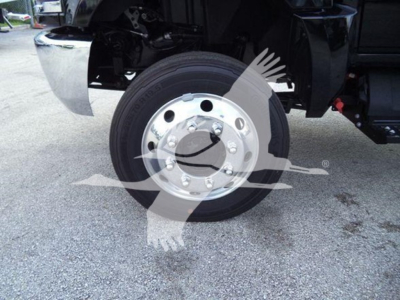 Truck wheel/axle area showing front tire and chrome hubcap, partial undercarriage components visible.