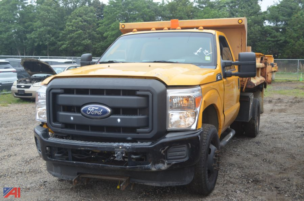 Ford F-350 Super Duty dump truck showing front view with yellow cab and black grille.