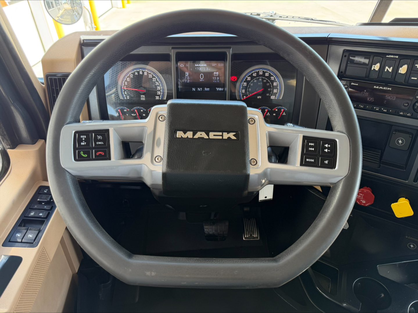 Mack steering wheel and dashboard in a 2023 Mack GR64F dump truck showing instrument cluster and control switches.