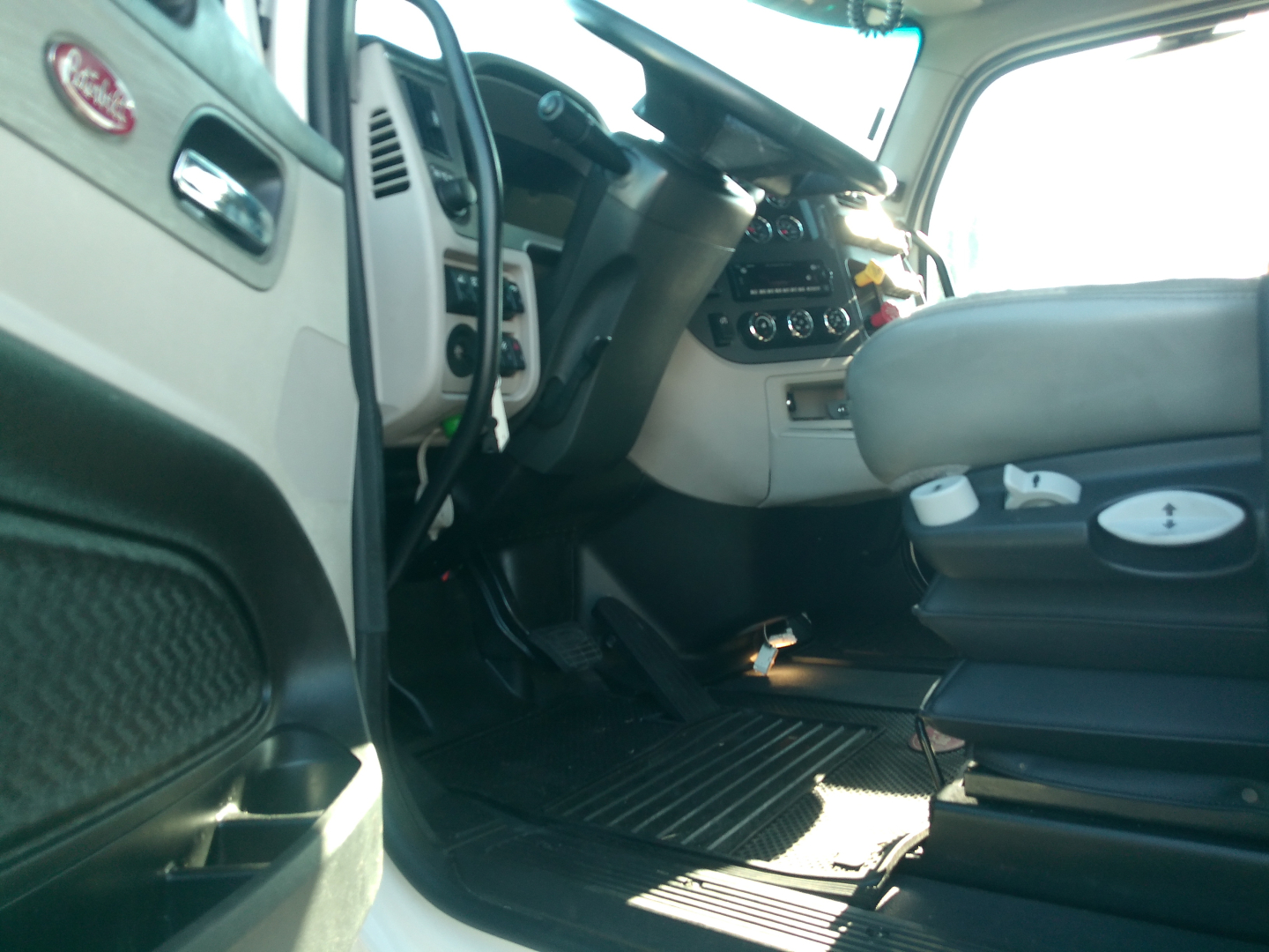 Peterbilt 579 cabin interior showing driver seat and dashboard area with steering wheel and center console.