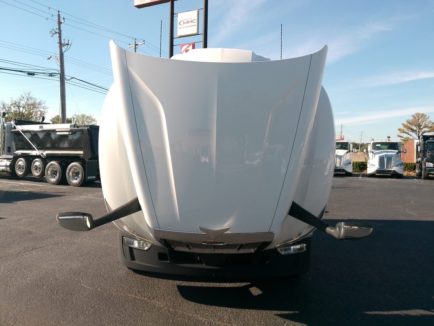 Front view of a 2023 Peterbilt 579 truck with its hood up, showing the engine bay area and mirrors, stock number 0632999 visible in listing context.