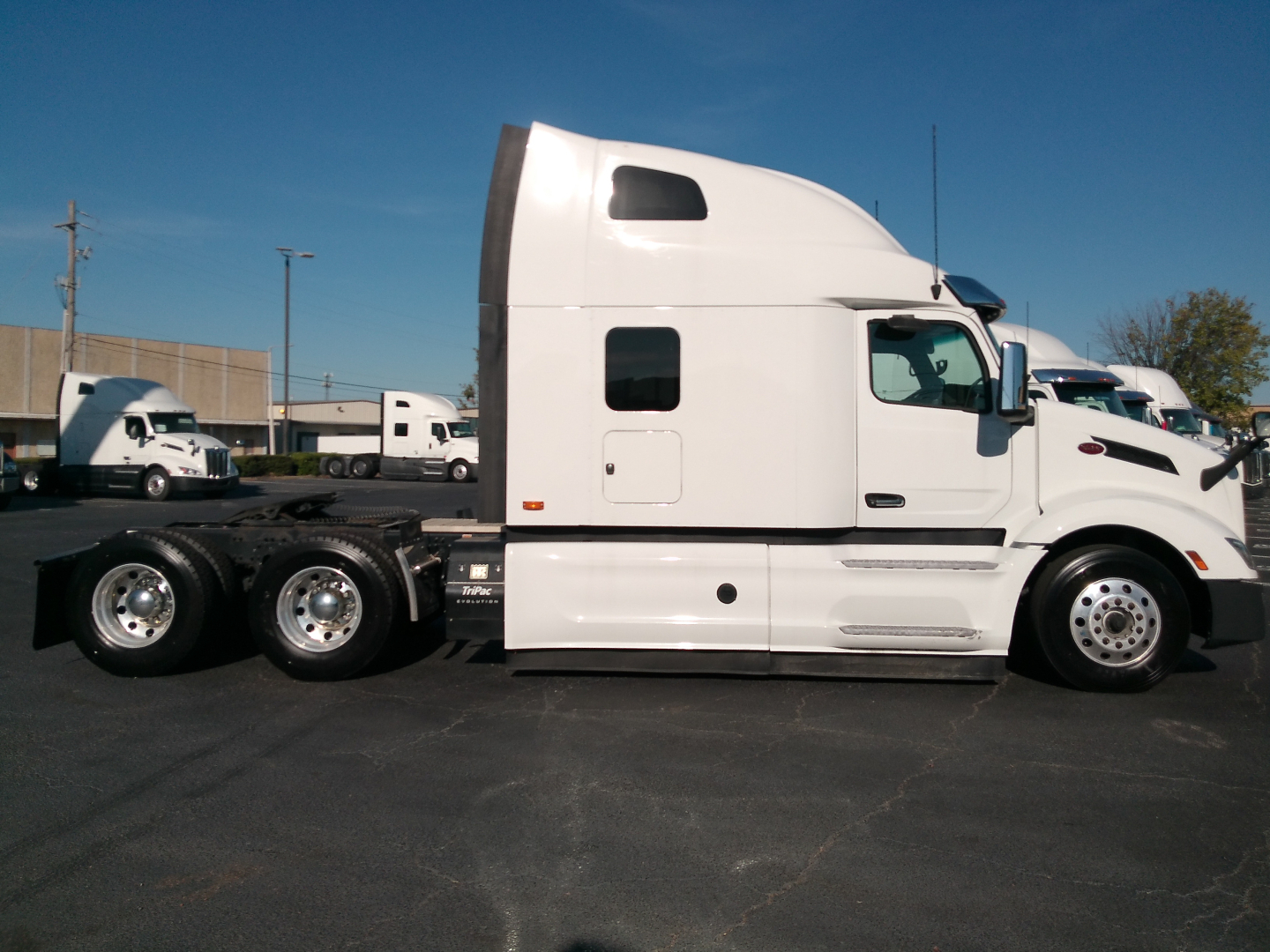 Peterbilt 579 sleeper cab tractor in white, side profile view