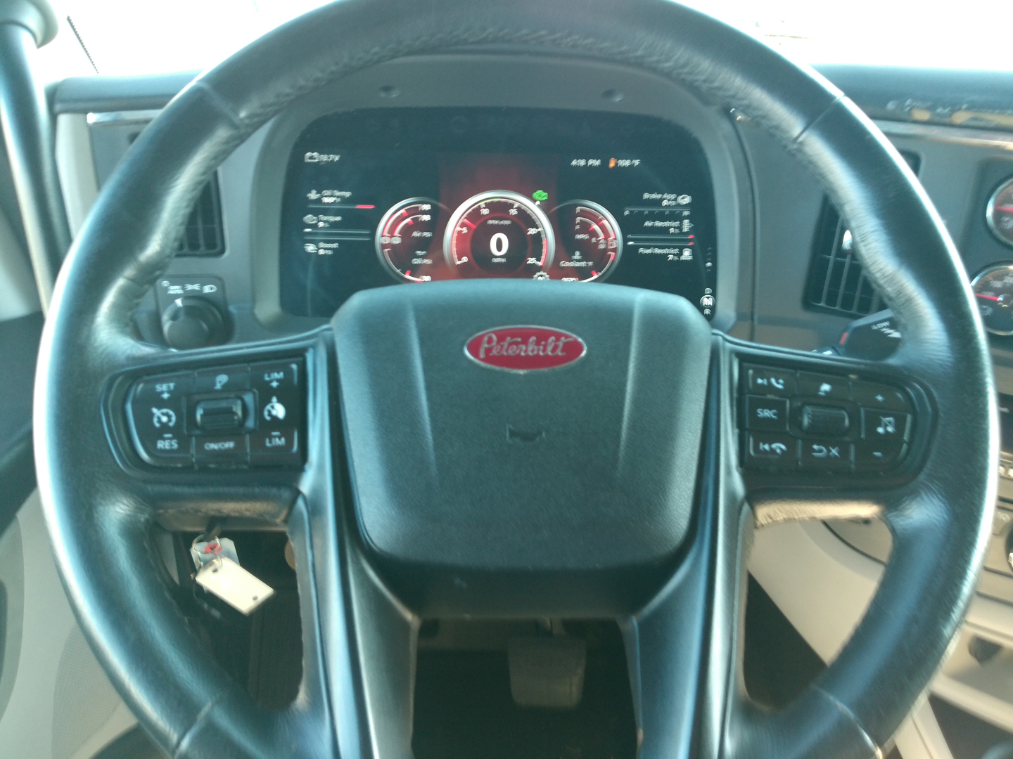 Peterbilt steering wheel and gauge cluster in cab showing dash controls and digital instrument cluster
