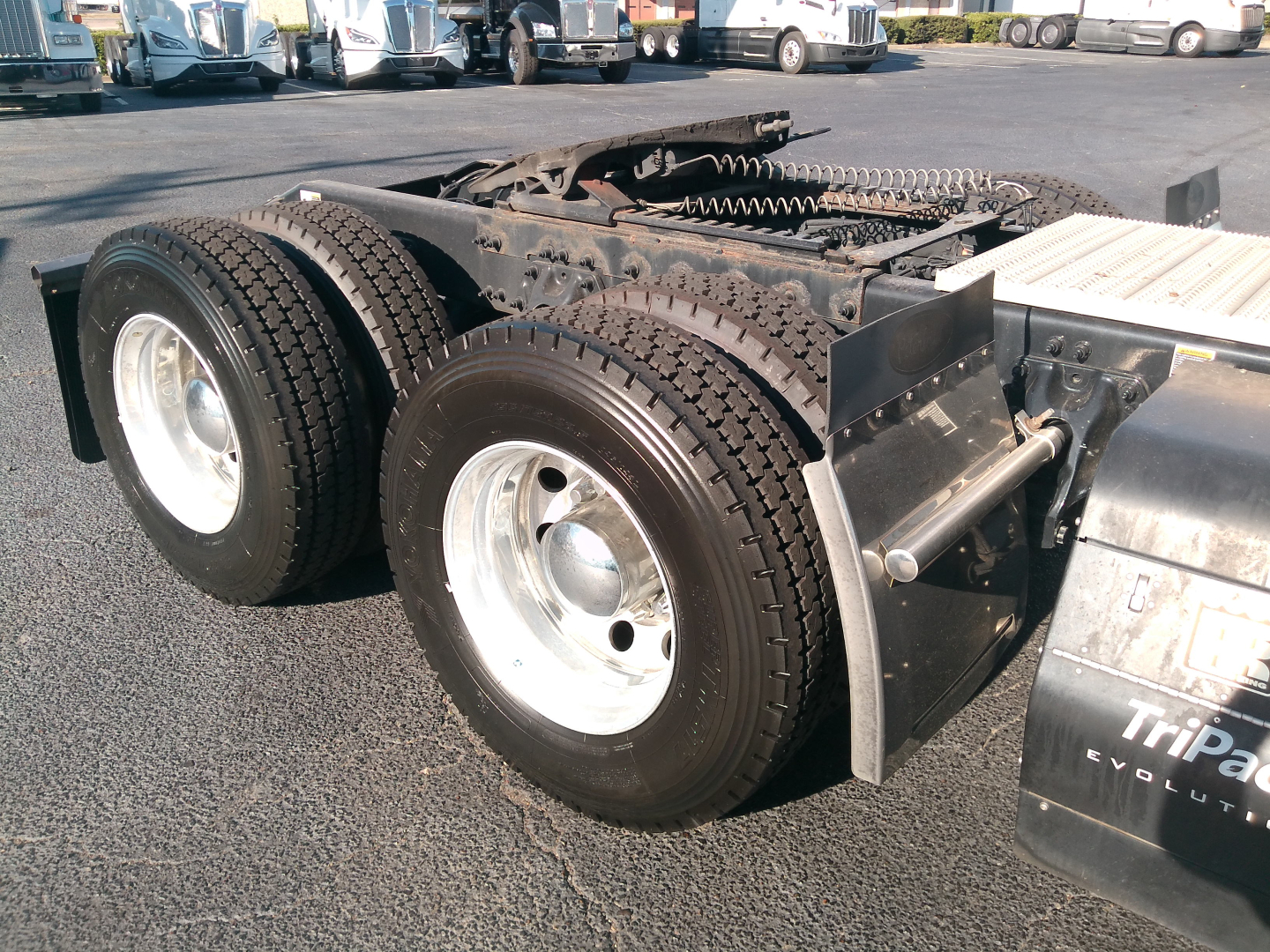 Peterbilt 579 truck rear dual axle tires and fifth-wheel area showing dual tires and mud flaps with TriPac Evolution label.