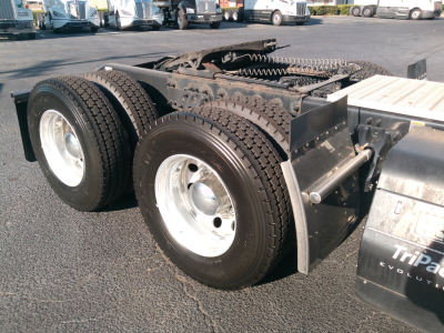 Peterbilt 579 truck rear dual axle tires and fifth-wheel area showing dual tires and mud flaps with TriPac Evolution label.