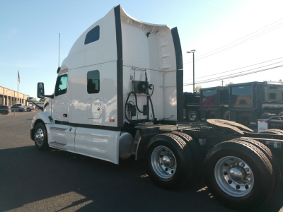 Peterbilt 579 truck cab and rear section with fuel/air lines, dual rear wheels, and white exterior.