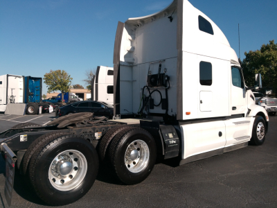 Peterbilt 579 truck sleeper cab with chassis and dual rear axles in a dealership lot.