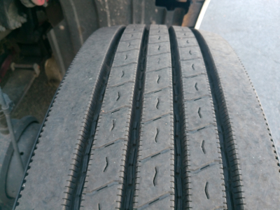 Truck wheel tire tread on Peterbilt 579 cab and front view showing worn tire tread and wheel area