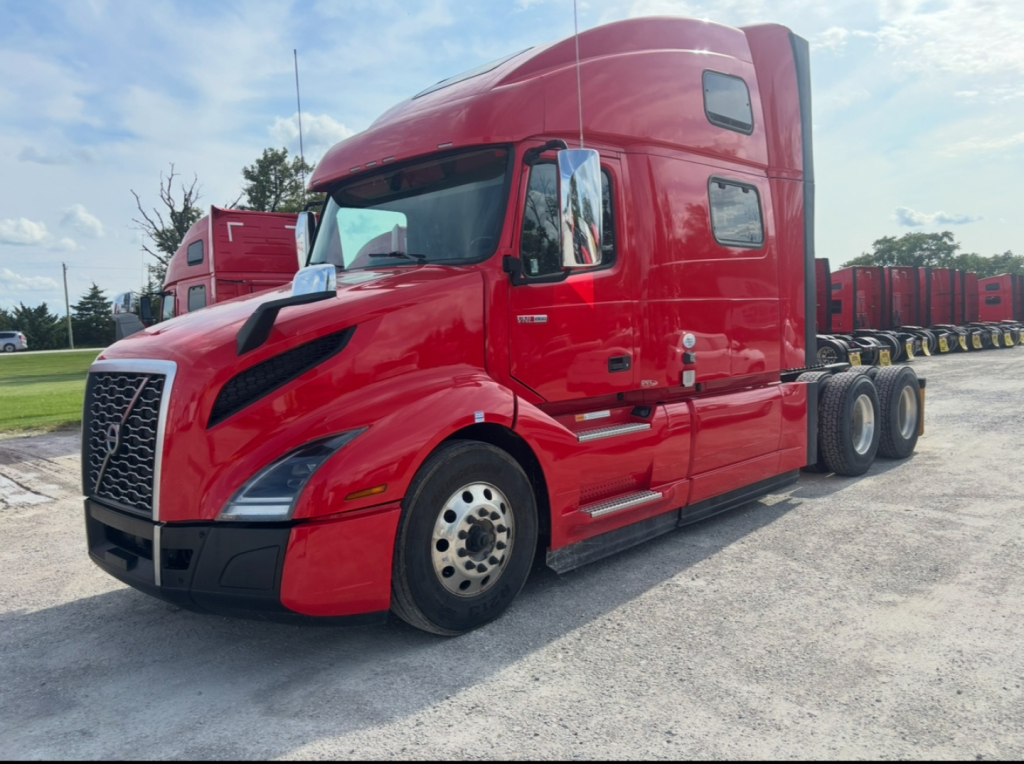 Volvo VNL64T860 truck in red, side view showing tractor cab and sleeper with chrome mirrors and front grille.