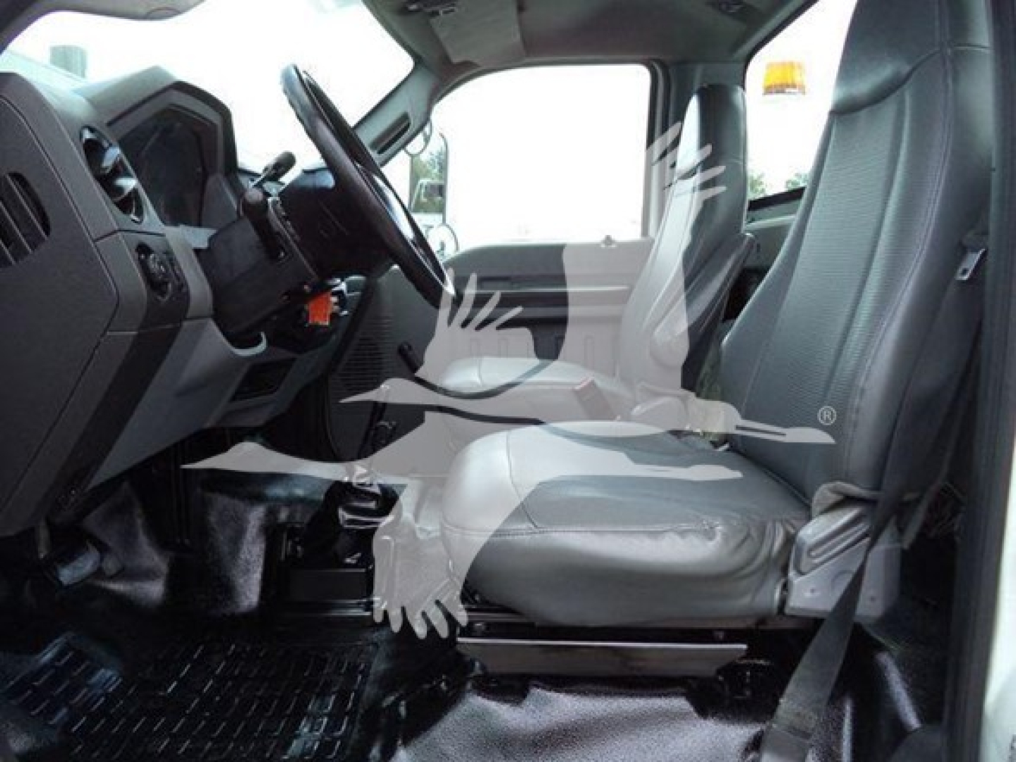 Inside cab of Versalift VST40i crane showing driver seat, steering wheel, dashboard, and passenger seat.