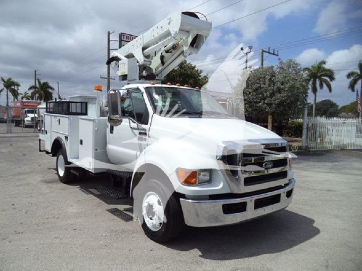 Versalift VST40i bucket truck crane on chassis showing mounted hydraulic boom and service body with compartments.