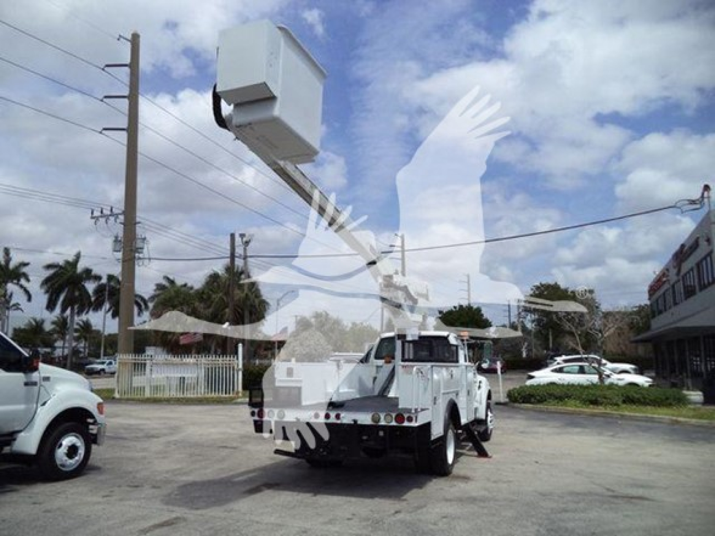 Versalift VST40i crane truck in a parking lot showing the crane assembly extended overhead.