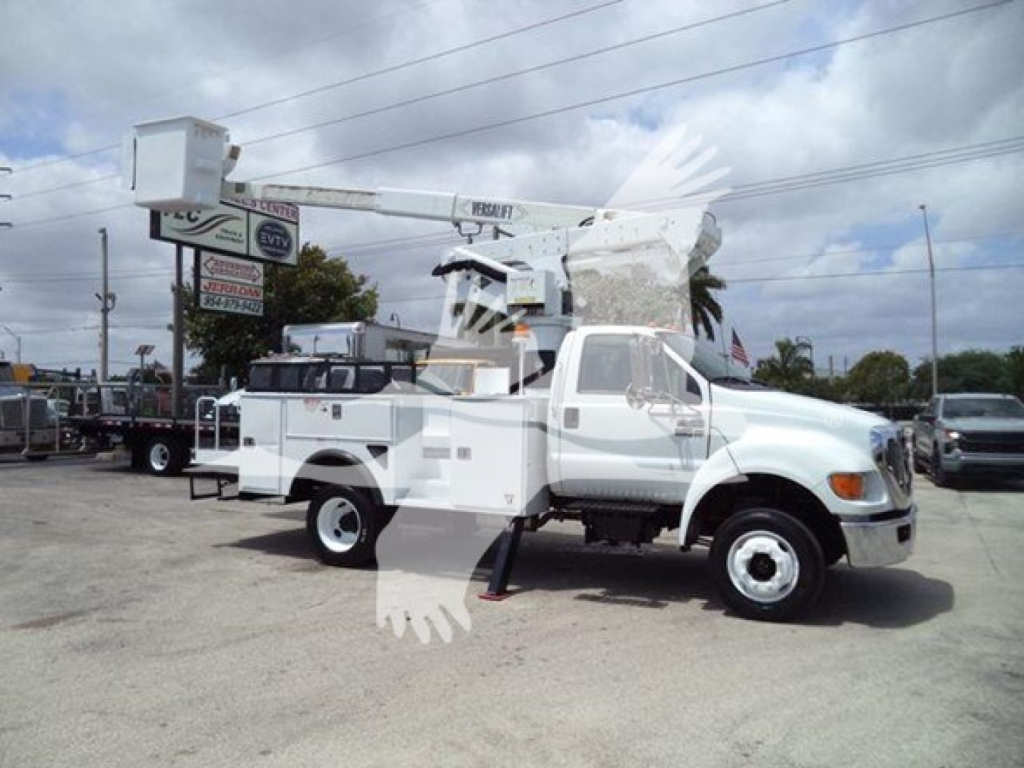 Versalift VST40i crane mounted on a white service truck, outriggers deployed, side view in a dealership lot.