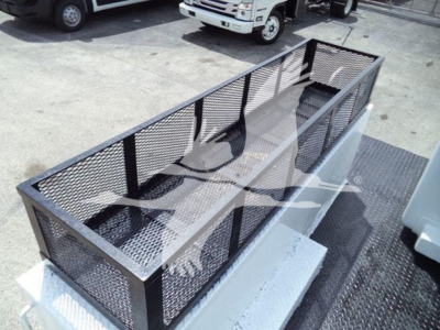 Versalift VST40i crane basket or platform with metal mesh sides and railing, mounted on a flatbed area of a truck in a lot.