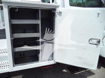 Versalift VST40I crane equipment rear cabinet open showing empty steel shelves and interior space.