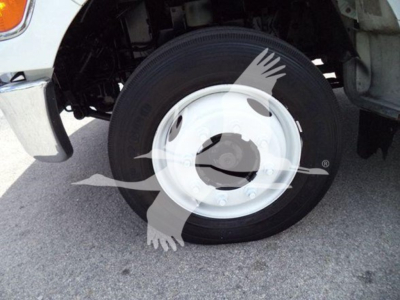 Front wheel and fender of a Versalift VST40i crane truck showing a white steel wheel with black tire and chassis components visible.