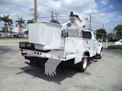 Versalift VST40i utility crane truck rear view showing white service body, outriggers, and crane arm folded over bed.