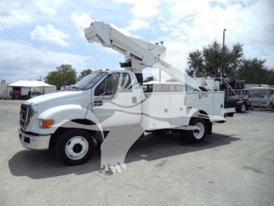 Versalift VST40i bucket truck/boom lift on a service truck with crane arm, side compartments, white color, front grille, wheels visible.