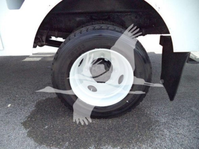 Tire and wheel of Versalift VST40i crane truck showing white steel rim and black tire with fender and undercarriage visible.