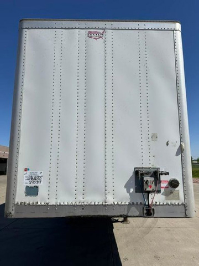 Rear view of a white 2016 Wabash van trailer with riveted panels, rear bumper, and access/lighting hardware visible.