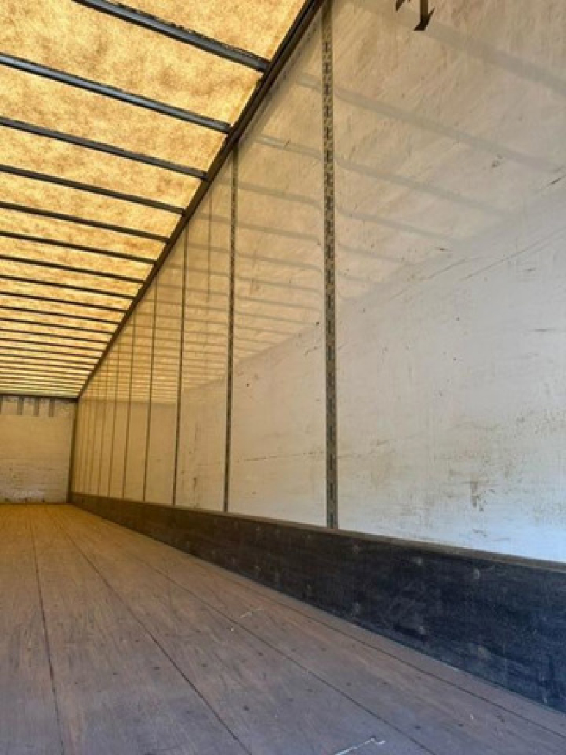 Trailer interior wall and ceiling of a 2016 Wabash van trailer showing wooden floor, side wall panels, and overhead framing.