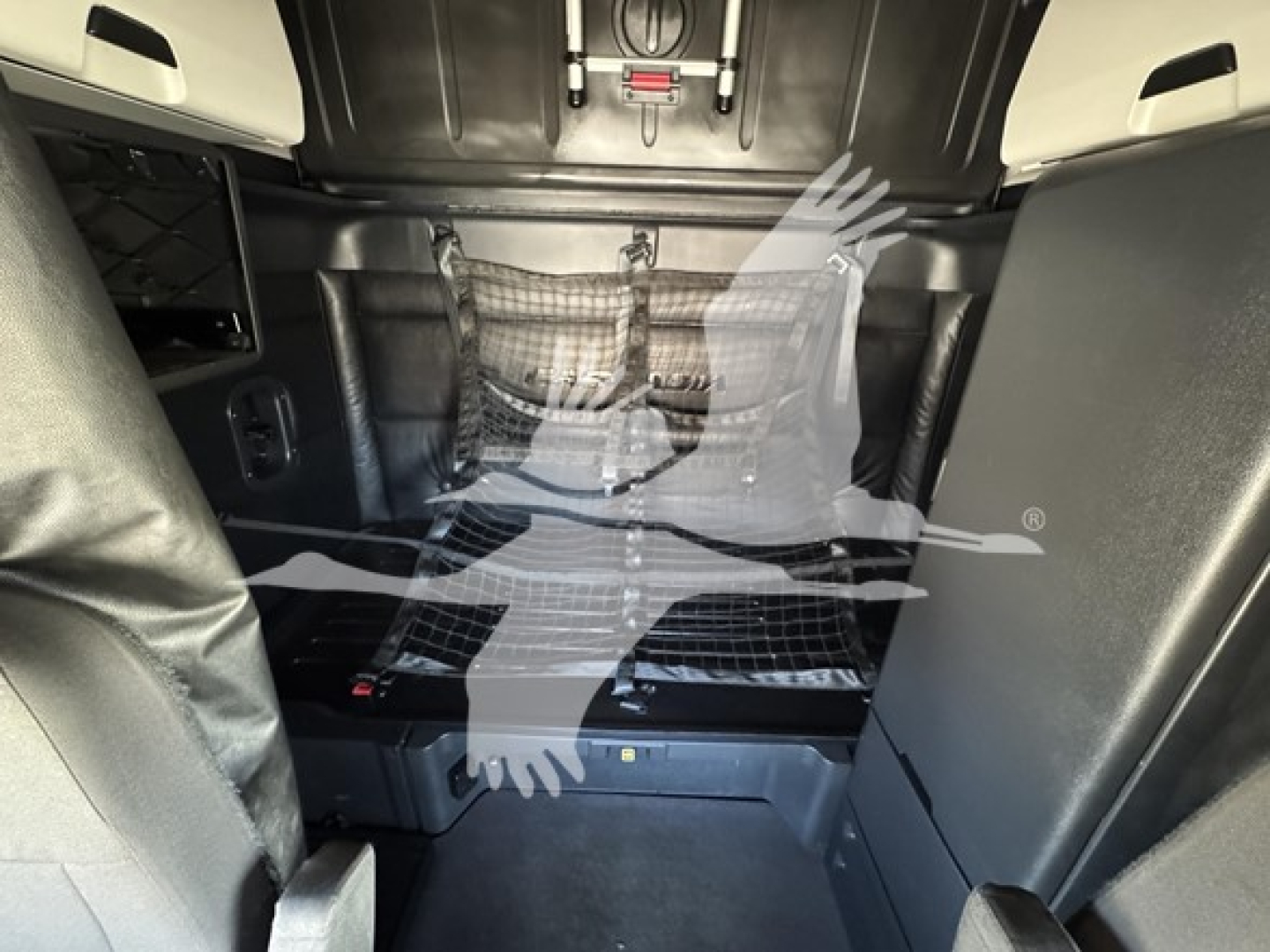 Freightliner Cascadia sleeper cab interior showing storage net and cargo area with overhead hooks visible.