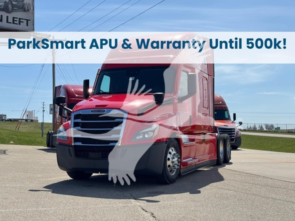 Freightliner Cascadia 126 truck with ParkSmart APU banner; windshield shows reflection, red cab, black bumper, parked on pavement.