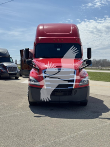 Front view of a red 2023 Freightliner Cascadia 126 sleeper truck with large grille and black bumper, white overlay graphic on hood and windshield reflection.