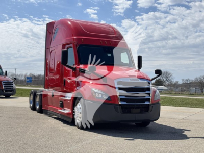 Truck front three-quarter view of a red 2023 Freightliner Cascadia 126 conventional sleeper tractor with chrome grille and black bumper.