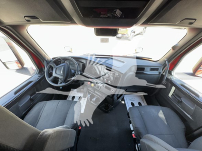 Dashboard and driver area of a Freightliner Cascadia 126 interior with steering wheel, center console, and seating. Visible text includes no legible labels besides standard truck interior features.