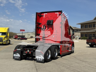 Freightliner Cascadia 126 tractor cab from rear three-quarter view in red with sleeper, dual rear axles, black mud flaps, and chrome wheels.