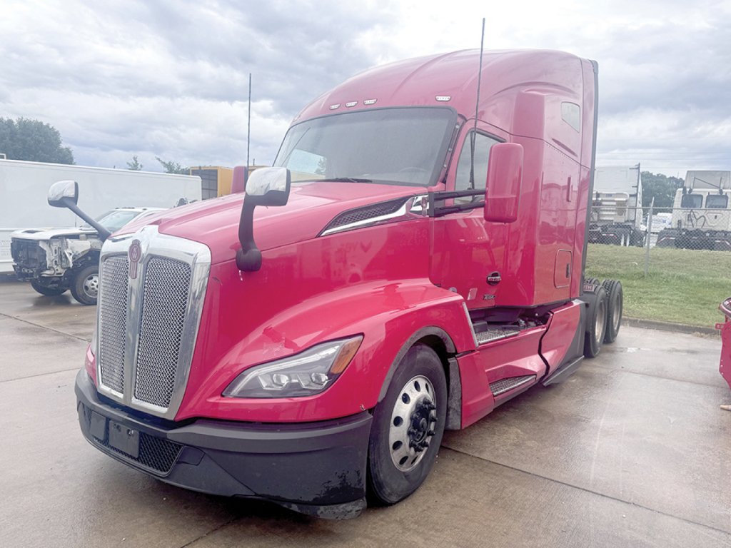 Kenworth T680 Next Gen tractor in red, front-left view, showing large chrome grille, sleeper cab, and dual rear axles without trailer.