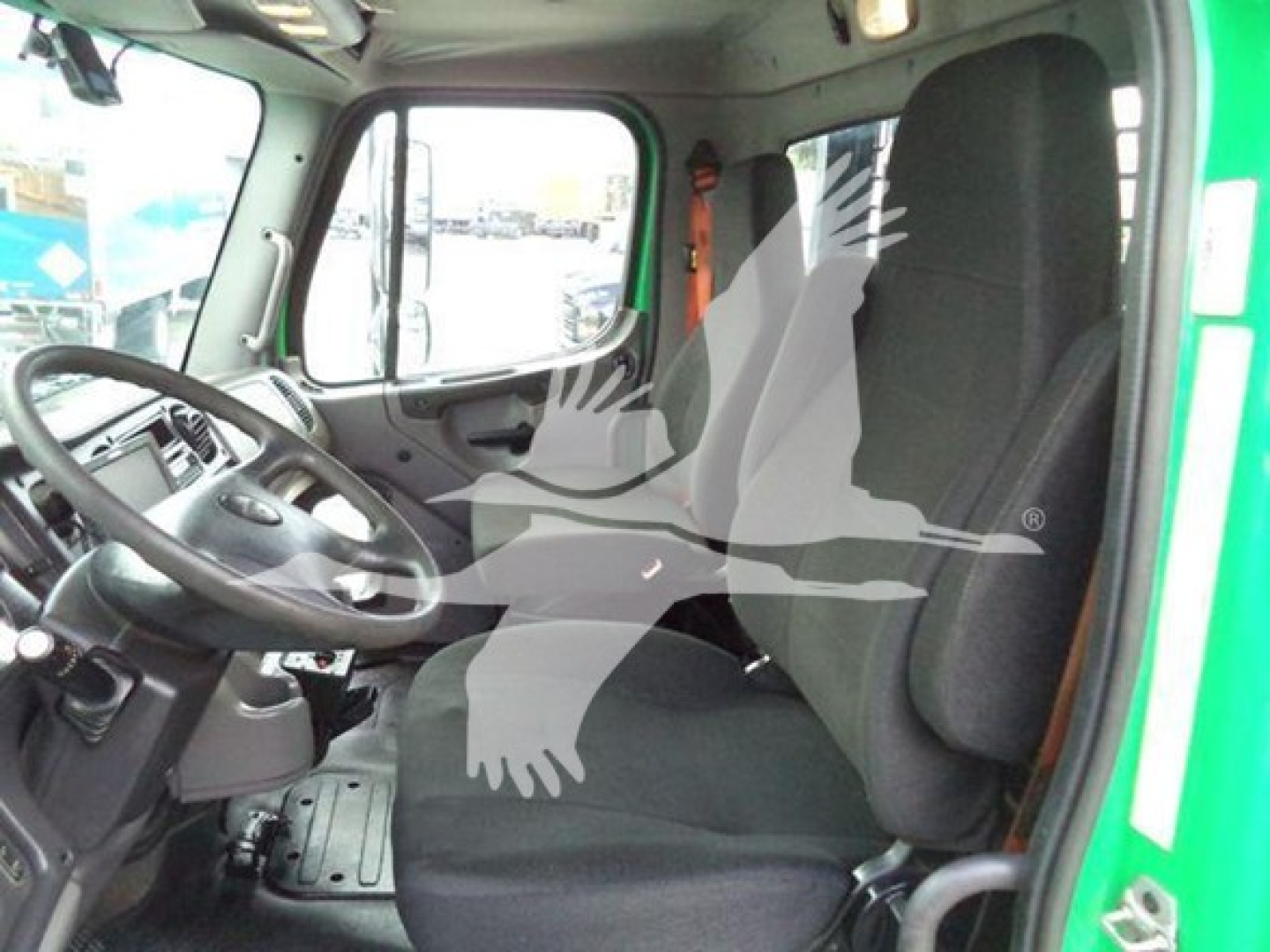 Truck cab interior showing steering wheel, driver seat, and dashboard of a Freightliner M2 106 with green exterior.
