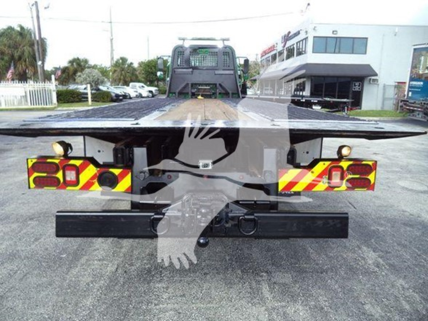 Flatbed tow truck bed with rear lights and bumper visible, Freightliner M2 106 style setup.