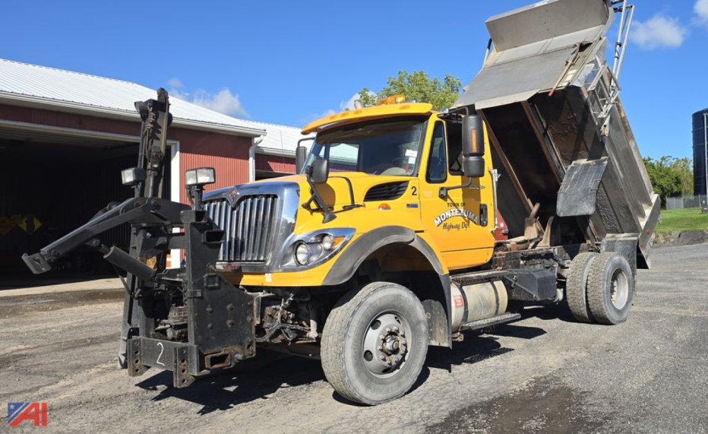 Dump truck in-service 2013 International SA537 WorkStar with raised dump bed, front plow attachment, and yellow cab. VIN 1HTWLAZR9DJ408797 visible on door.