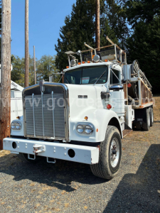 Kenworth W900A concrete mixer truck in white, front view showing large grille, round headlights, bumper, and mixer drum equipment on the chassis.